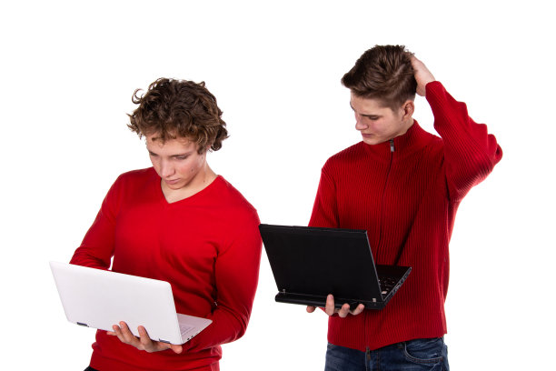 学习和工作。两个漂亮的年轻学生拿着笔记本电脑。白色背景。图片下载