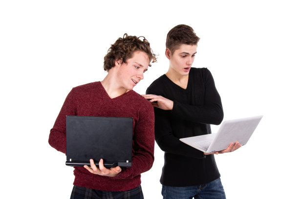 学习和工作。两个漂亮的年轻学生拿着笔记本电脑。白色背景。图片下载