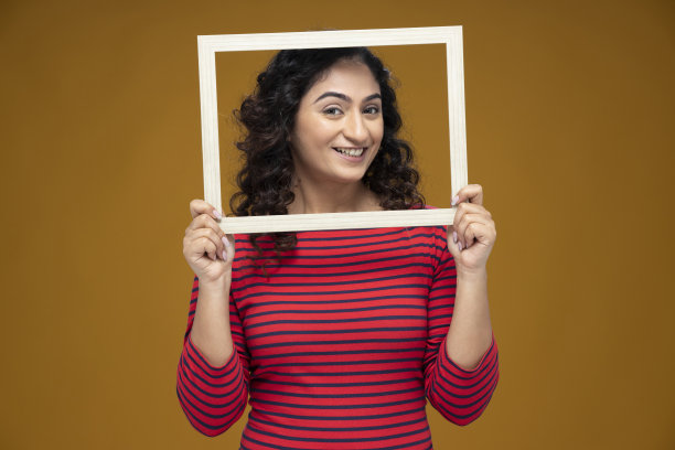 年轻女子的肖像站在黄色背景，股票照片图片下载