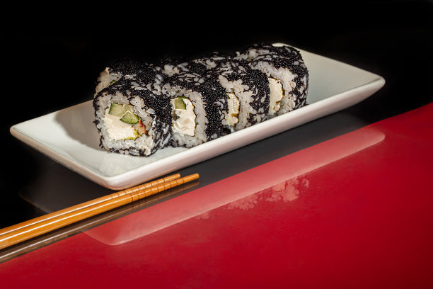 寿司套餐，费城，加州，浦卷，白色盘子。喜庆新年的概念。在黑暗的反光背景下。图片下载