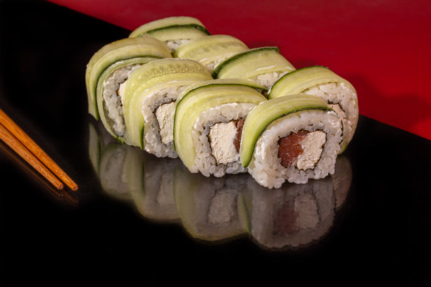 寿司套餐，费城，加州，浦卷，白色盘子。喜庆新年的概念。在黑暗的反光背景下。图片下载