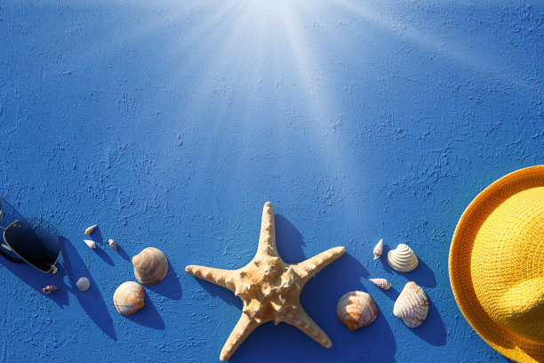 以海洋主题的沙滩饰品为框架:黄色草帽、太阳镜、海星和贝壳在蓝色背景上。度假理念、海上旅行、防紫外线、游泳。副本的空间。Flatlay图片下载