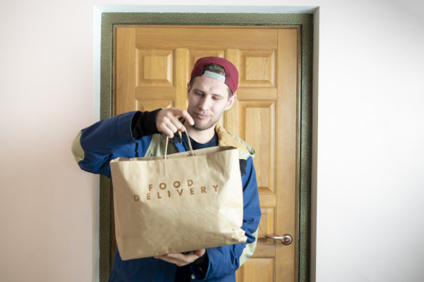 年轻人拿着一个纸袋，递送产品图片下载