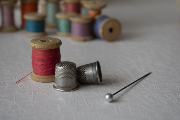 老式线轴，针和顶针放在桌子上图片下载