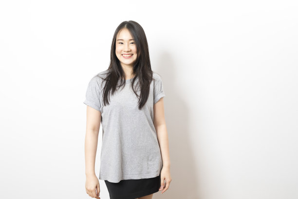 肖像快乐的年轻亚洲妇女穿着灰色衬衫微笑在白色的背景。图片下载