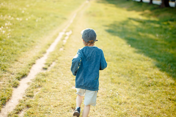 8岁男孩在草地上奔跑，戴着防护面具图片下载