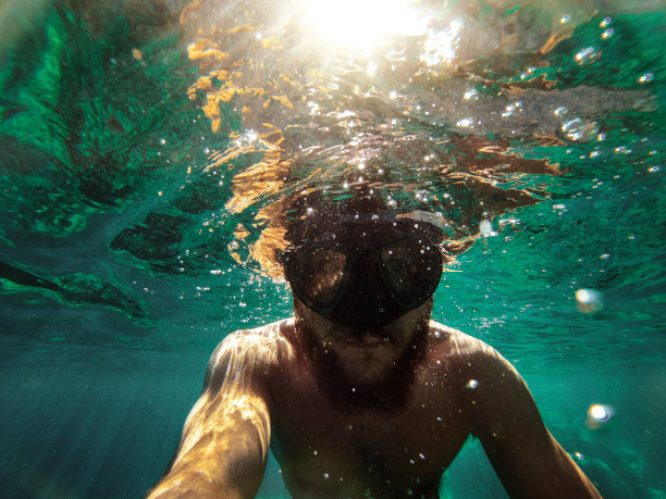 一个男人在夏天的海里游泳和浮潜的自拍图片下载