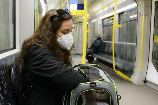 年轻女人戴着口罩在地铁里抱着一只猫图片下载