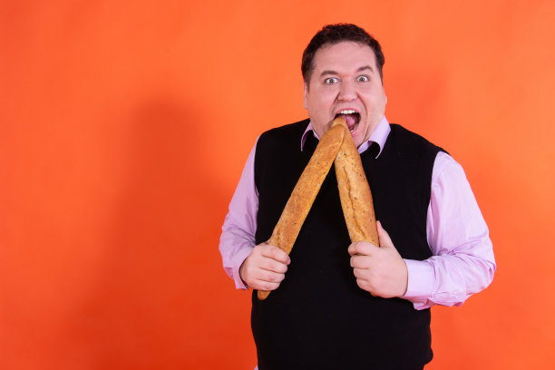 饮食风趣的人。那个胖子正在吃一个小披萨。图片下载