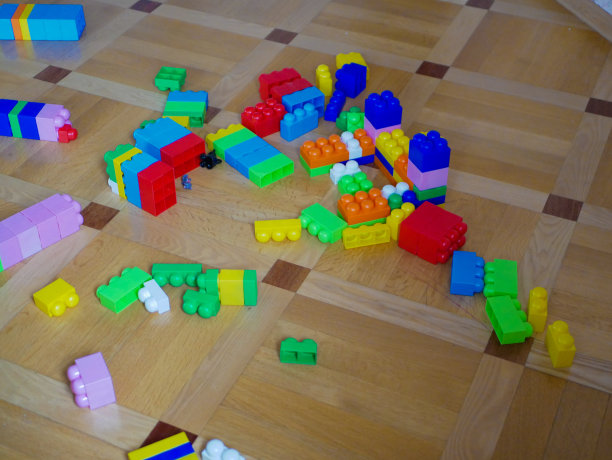 五颜六色的塑料积木散落在地板上。学龄前儿童幼儿园的游戏场地。图片下载