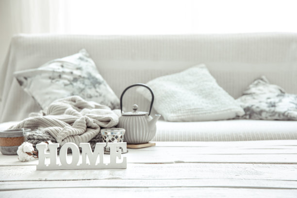 客厅的桌子上有一个带有hygge装饰细节的茶壶和一个装饰性的“家”字。图片下载