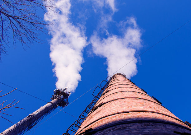 烟雾从化工厂烟囱在多云的天空背景。生态的主题。图片下载