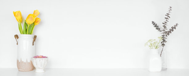 架子上的家居装饰。花，树枝和植物。白色的架子靠着白色的墙。图片下载