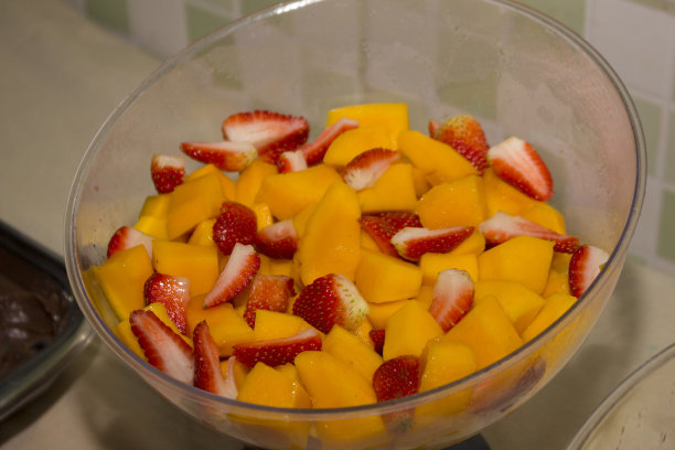 芒果和草莓切成美味的热带水果沙拉。美食摄影。健康食品。图片下载