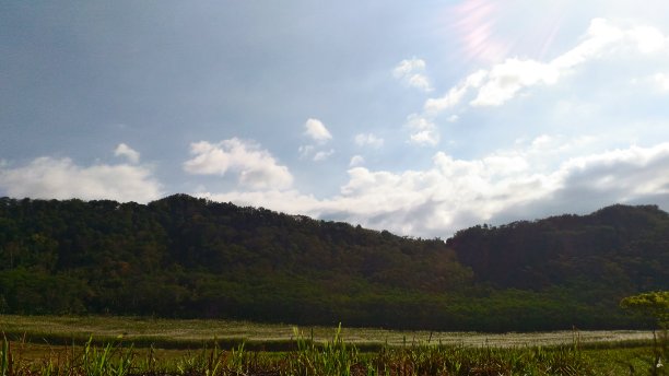 白天有蓝天、白云和阳光的山景图片下载