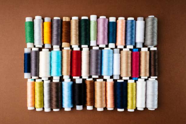 许多不同的卷轴与线，平铺，俯视图。彩色线，特写，明亮的背景。裁剪和缝纫服装的概念。附件为刺绣图片下载