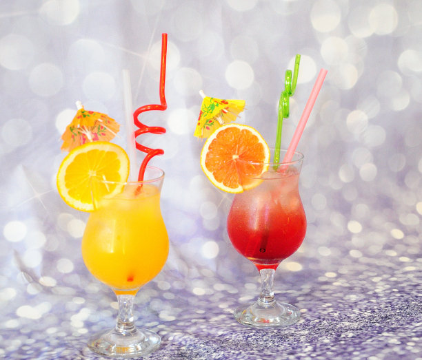 两杯橘子汁和冰，在灰色的背景上装饰着橘子片和葡萄柚片。图片下载