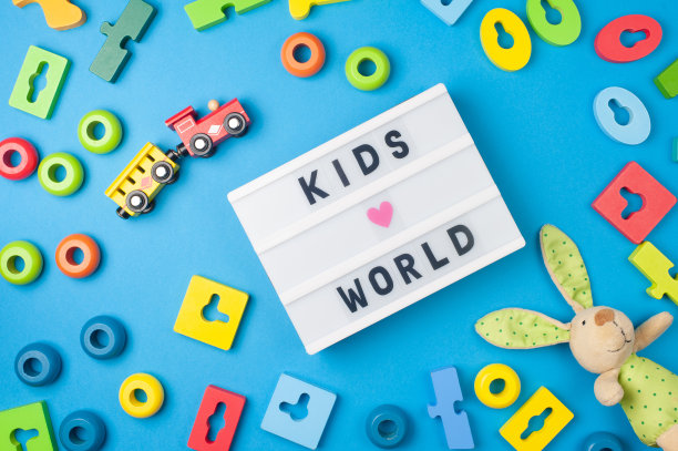 儿童世界-文字显示灯箱和玩具的孩子在蓝色的背景。平的。Ð五颜六色的木制玩具，兔子和火车。图片下载