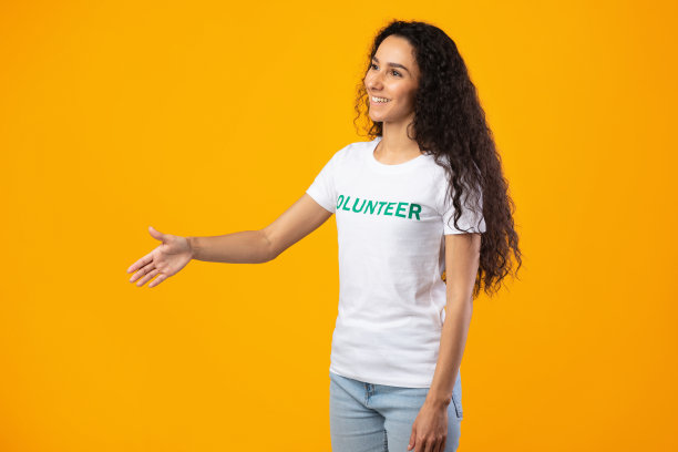 侧视图的志愿者女士伸出手握手，黄色背景图片下载