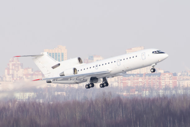 机场在城市附近。飞机在多层建筑、城市景观的背景下起飞。图片下载