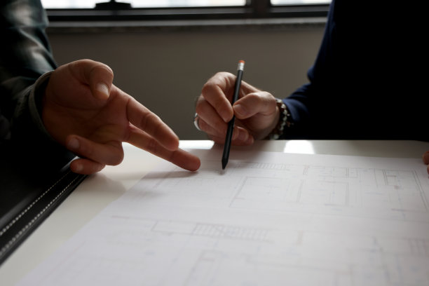 特写手握笔与建筑项目图片下载