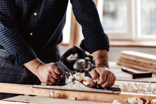 木匠的手用手刨刨一块木板图片下载
