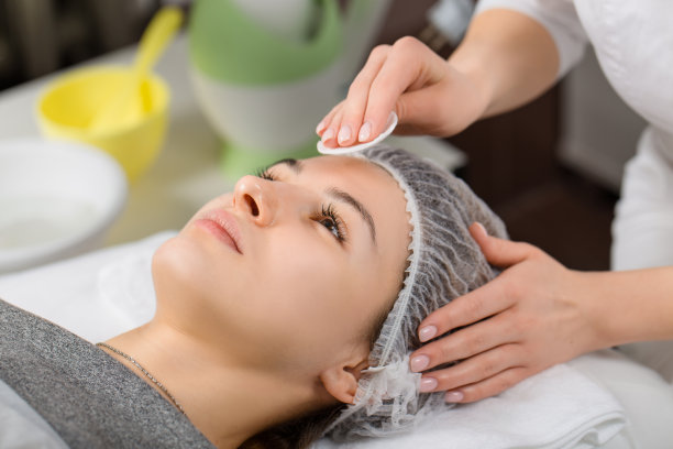 年轻美丽的女人正在接受面部按摩图片下载