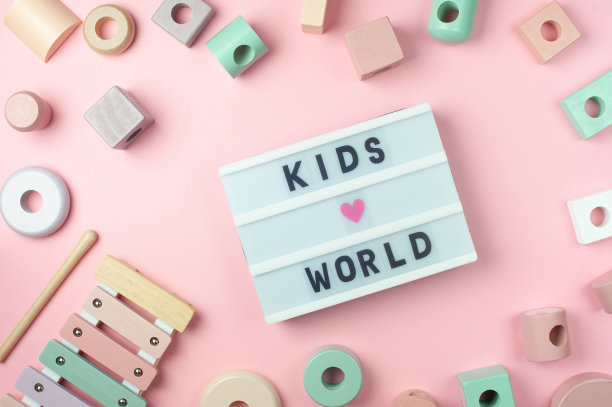 儿童世界-文字显示灯箱和玩具的小孩在粉红色的背景。平的。Ð彩色蜡笔木制玩具、木琴。图片下载