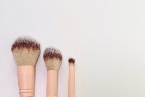 三种大小的化妆刷在白色的桌子背景图片下载