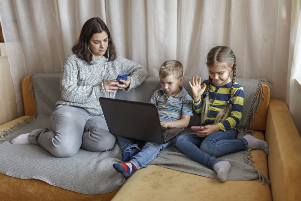 妈妈和孩子们坐在沙发上，不再使用社交媒体平台、音频、信息和视频图片下载