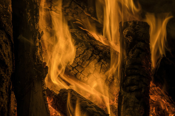 夏天来了，发生火灾的风险增加了。一个惊人的自然纹理图案燃烧的木材与火焰的细节图片下载
