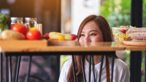 一个漂亮的女厨师拿着并看着厨房柜台上的食物图片下载