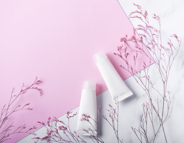 大理石和粉红色背景上的白色奶油管图片下载