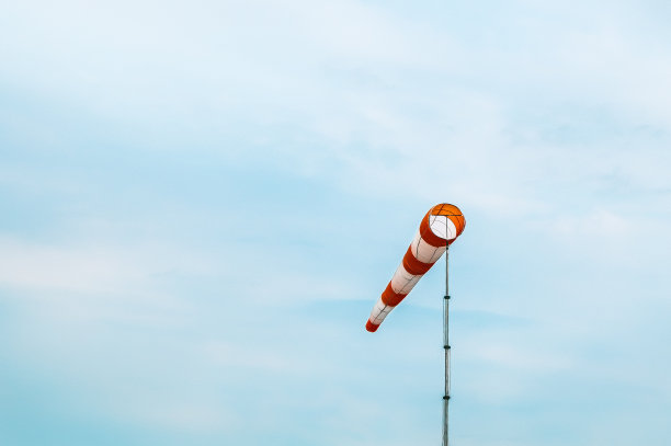 红色和白色条纹的风向标在蓝色的天空背景图片下载