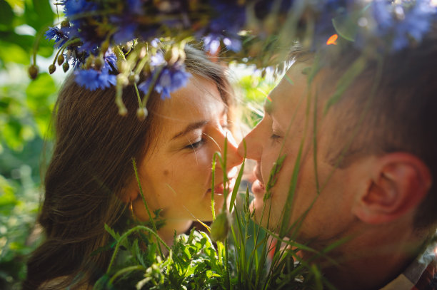 这是一对情侣在阳光明媚的日子里在户外接吻的照片。有选择性的重点。的爱情故事图片下载