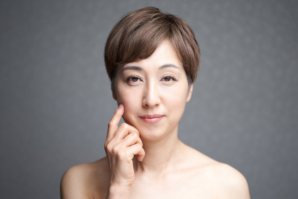 中年日本妇女检查她的面颊的紧实图片下载
