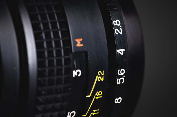 一个手持式旧镜头的聚焦环和光圈的特写。照片的背景图片下载
