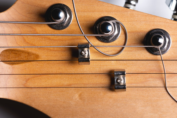 灰色背景上有调音栓和弦的吉他指板。特写镜头图片下载