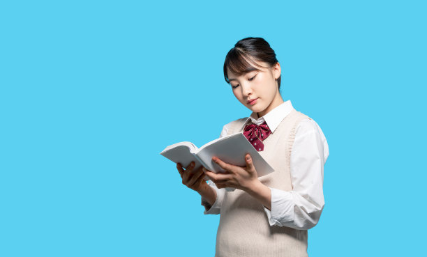 一个亚洲高中女生在读一本书。图片下载