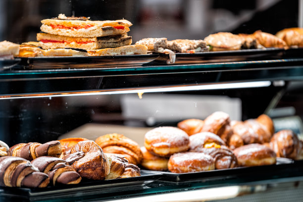 许多不同的各种各样的巧克力糖甜甜圈烘焙食品近距离展示在面包店的玻璃窗户后，锡耶纳，意大利图片下载