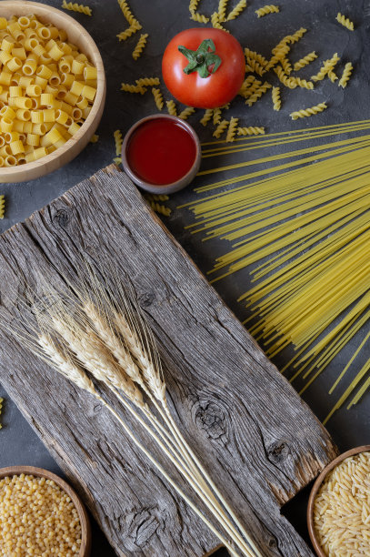 各种生意大利面，新鲜番茄和酱石背景，生食概念图片下载