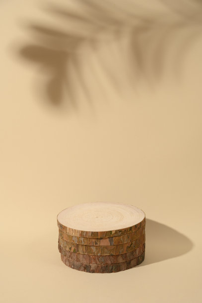 圆形木制讲台上的米色背景化妆品。带有阴影的单色创意构图。前视图。图片下载