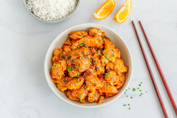 新鲜橙汁鸡在碗与米饭和筷子装饰新鲜橙水果俯视图水平照片图片下载