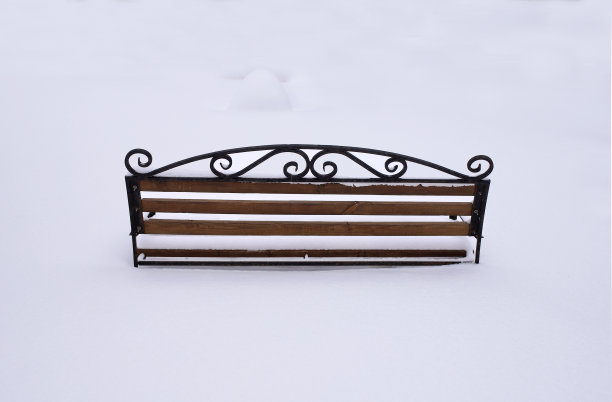 一场暴风雪过后，白雪覆盖的镂空长凳图片下载
