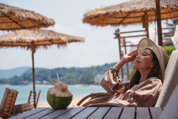 一位年轻美丽的亚洲女子喜欢坐在海滩上图片下载