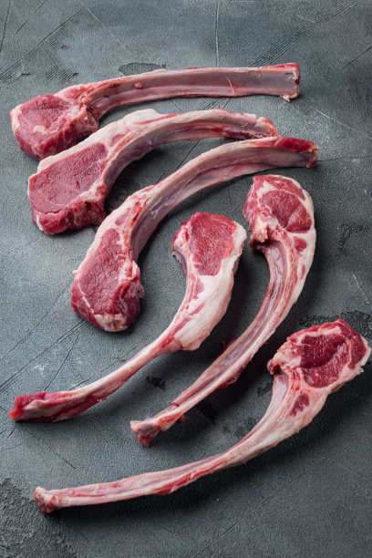 在灰色的石头背景上，准备烹饪的羊肉架素材图片