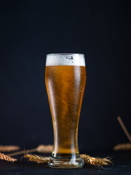 一张深色的桌子上放着一杯淡啤酒图片下载