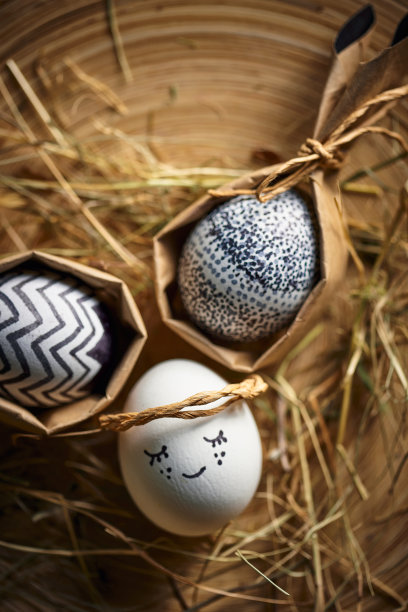 稻草上的复活节彩蛋。可爱的天使蛋躺在干草上，问候节日贺卡在春天的宗教节日图片下载