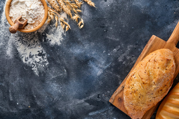 各种酥脆的面包、小麦粉和穗子放在灰色的老混凝土背景桌上。俯视图平铺与复制空间图片下载