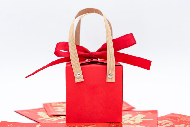 一盒红礼物压在一堆红包上图片下载